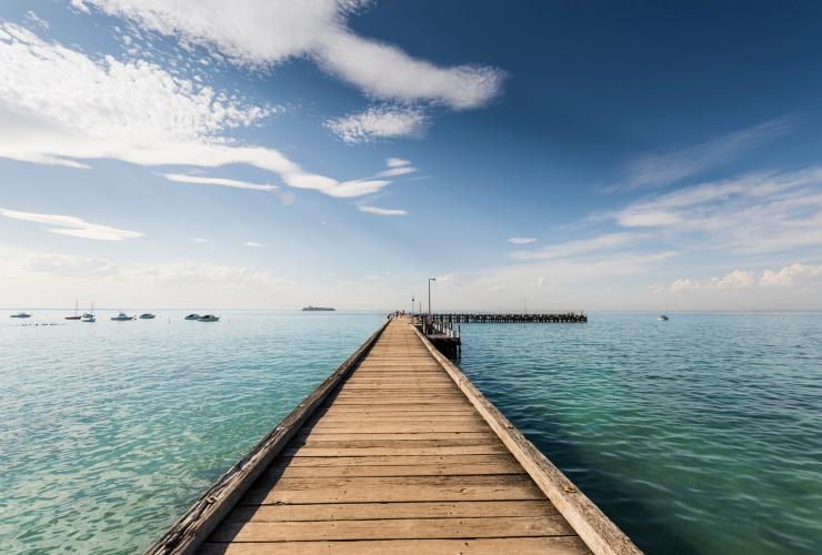 Cầu tàu vươn ra một vịnh nước êm đềm, với thuyền neo đậu gần đó, Cầu tàu Portsea, Bán đảo Mornington, Tiểu bang Victoria © Mornington Peninsula