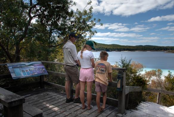Children standing with a tour guide at a lookout overlooking a lake near Kingfisher Bay Resort, K'gari, Queensland © Tourism and Events Queensland