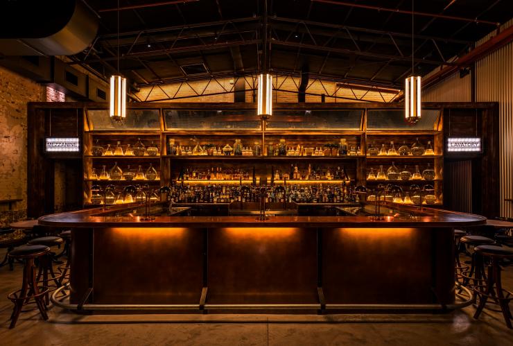 View of the well-stocked bar and dimly lit lights at Archie Rose, Sydney, New South Wales © Archie Rose