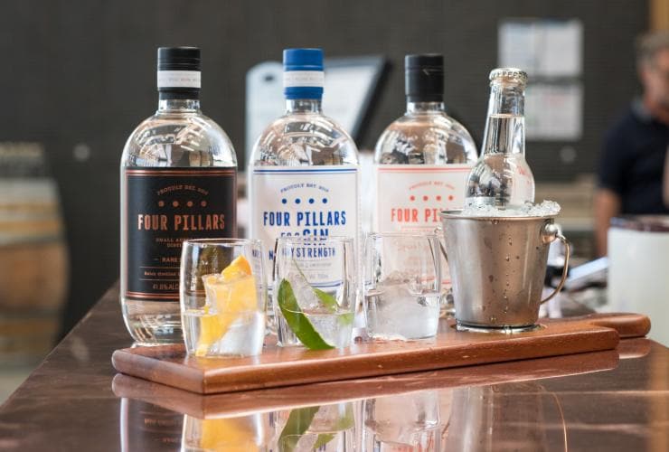 A row of gin bottles behind glasses with fresh garnished during a gin tasting at Four Pillars Gin, Yarra Valley, Victoria © Four Pillars