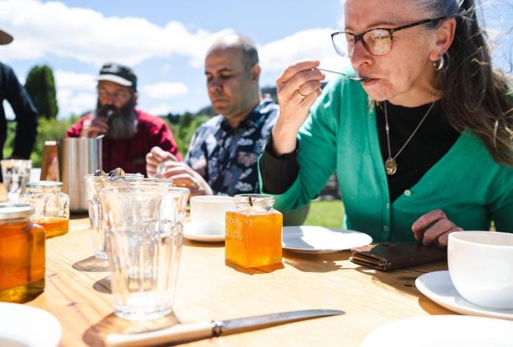A group tasting golden honey at Bowral Beekeeping, Southern Highlands, New South Wales © Tourism Australia