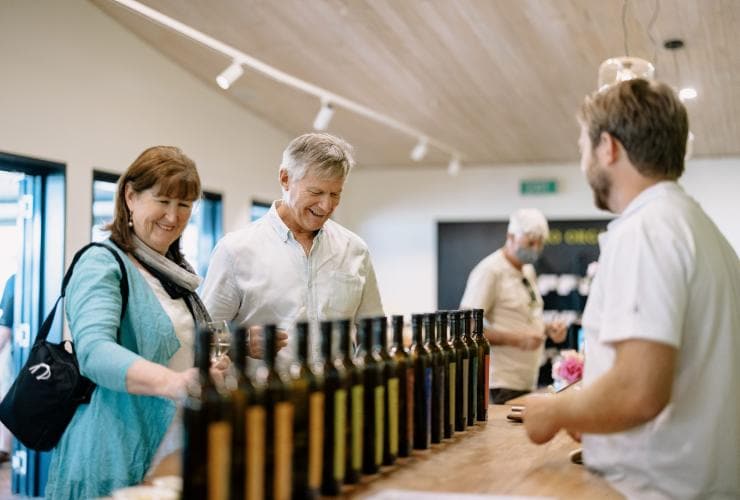 Couple browsing varieties of olive oil at Olio Bello, Margaret River, Western Australia © Tourism Australia 