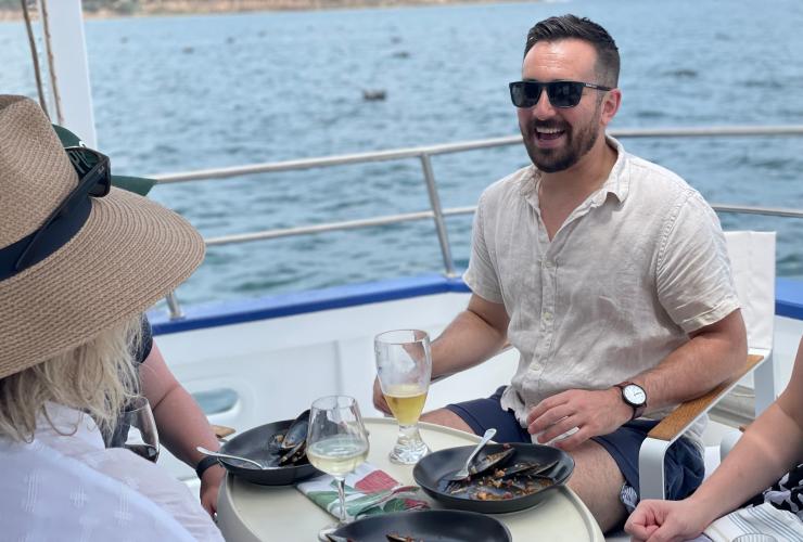 A group on a tour boat enjoying drinks and fresh mussels with Portarlington Mussel Tours, Bellarine Peninsula, Victoria © Geelong and the Bellarine