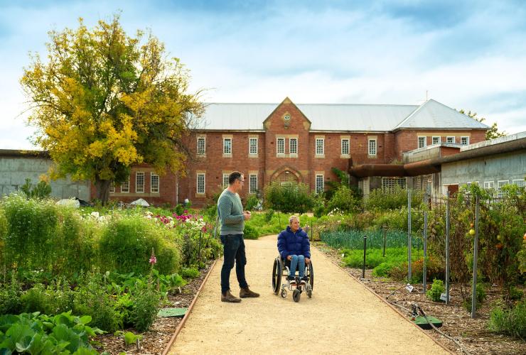 A woman in a wheelchair and a man chat in front of The Agrarian Kitchen, Southern Tasmania, Tasmania © Tourism Australia
