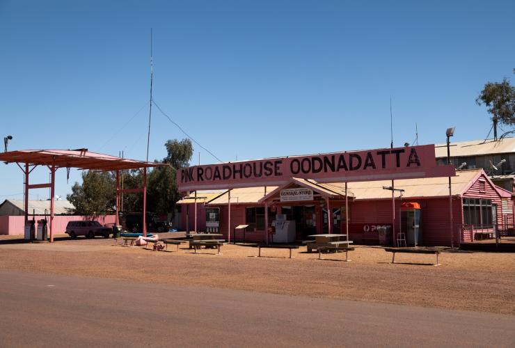 A pink building with a painted sign reading "Pink Roadhouse Oodnadatta", Flinders Ranges & Outback, South Australia © South Australia Tourism Commission