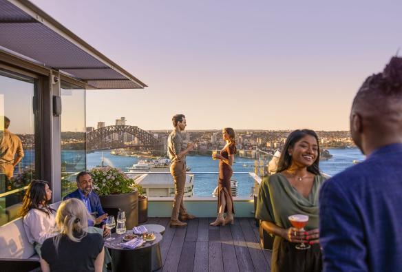 Guests enjoy drinks with views of the Sydney Harbour from Aster, Sydney, New South Wales © Tourism Australia