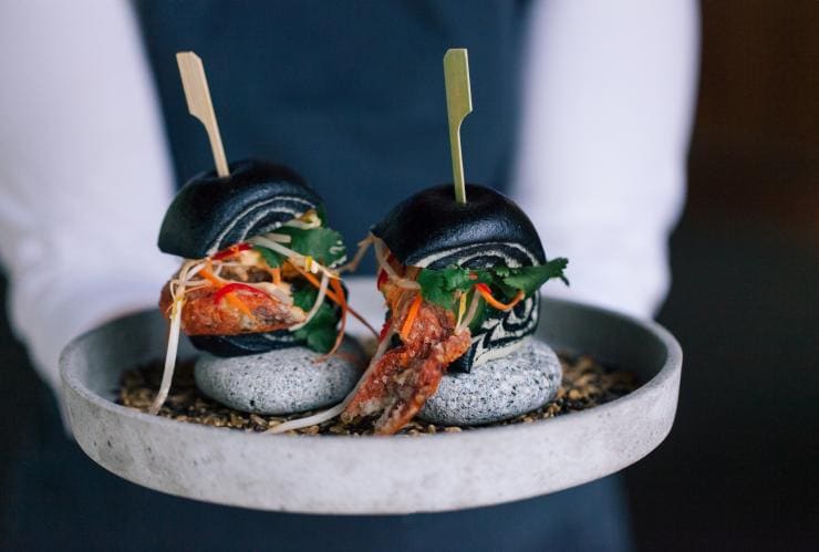 A person holding a plate of two slides filled with mud crab at The Boat House, Canberra, Australian Capital Territory © The Boat House