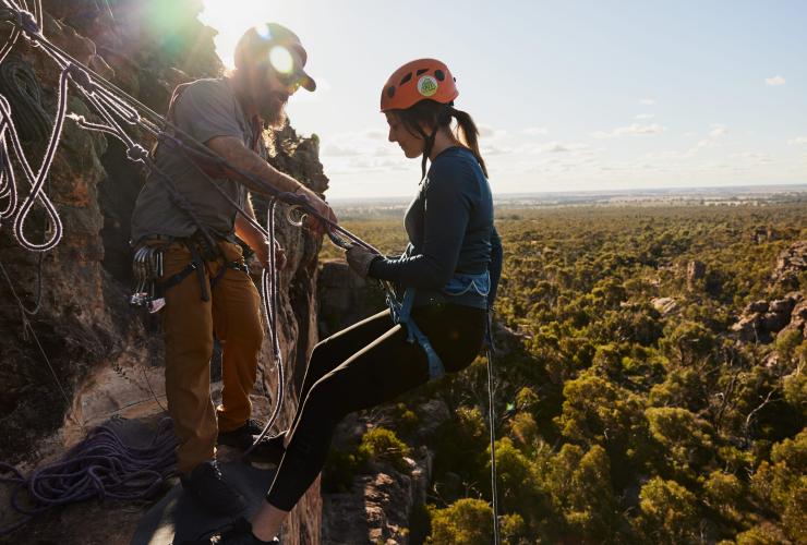 Một người đang đu dây xuống vách đá phía trên vùng cây bụi, Hangin' Out, Vùng Grampians, Tiểu bang Victoria © Tourism Australia