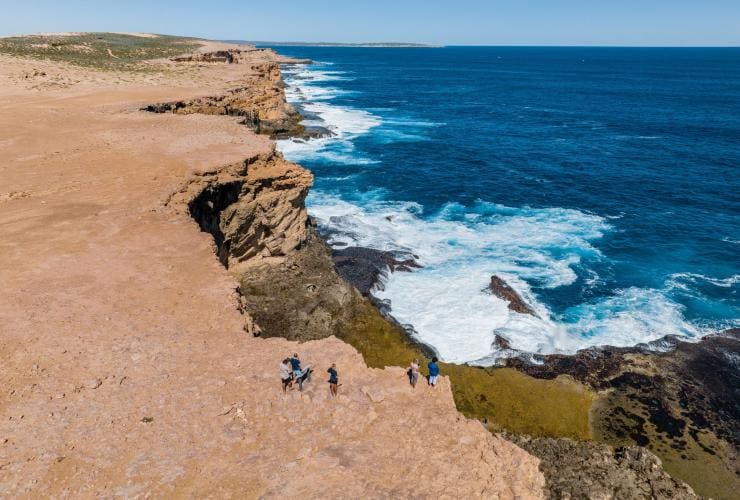 Hình ảnh nhìn từ trên cao một nhóm người đang tham quan đường bờ biển đá, Dirk Hartog Island Life Adventures, Đảo Dirk Hartog, Tiểu bang Tây Úc © Tourism Australia