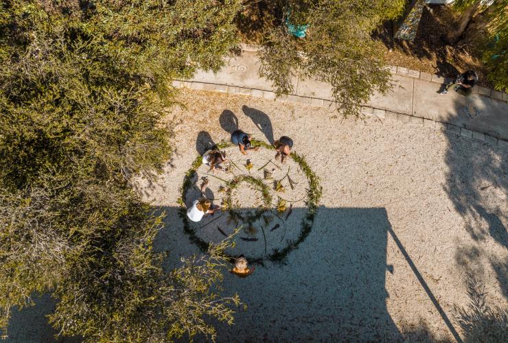Aerial view of a group of people creating patterns in the ground using plants and flowers with Untamed Escapes, Esperance, Western Australia © Tourism Australia