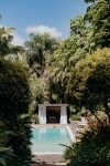 View through trees towards a pool and cabana surrounded by greenery at Gaia Retreat & Spa, Byron Bay, New South Wales © Gaia Retreat & Spa
