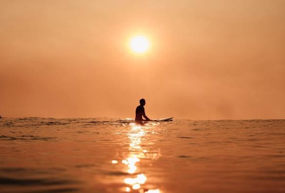 A surfer captured at sunrise, waiting for a wave at Bondi Beach, Sydney NSW © Tourism Australia