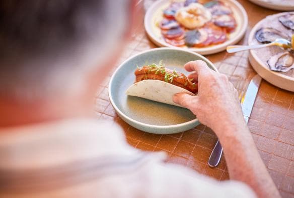 Một người đang dùng bữa với bánh taco và hải sản tươi sống, Splendour Tailored Tours, Thành phố Sydney, Tiểu bang New South Wales © Tourism Australia