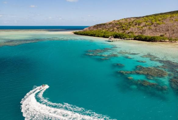 An aerial view of a jetski creating a white wake behind it near Haggerstone Island, Great Barrier Reef, Queensland © Tourism and Events Queensland