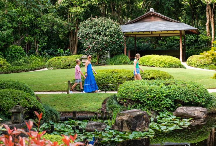 A family wandering through the lush greenery and ponds within Brisbane Botanic Gardens, Mount Coot-Tha, Brisbane, Queensland © Tourism and Events Queensland