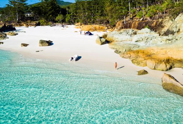 A few people enjoying an empty beach and bright blue water at Betty's Beach, Whitsundays, Queensland © Tourism and Events Queensland