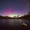 The Aurora Australis (Southern Lights) shining in purple and green hues behind the snow-capped peaks of Cradle Mountain-Lake St Clair National park, Tasmania © Pierre Destribats