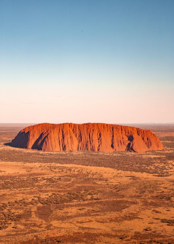 Ảnh chụp từ trên cao khối đá nguyên khối đỏ Uluru và các đồng cỏ xung quanh tại Vườn quốc gia Uluru-Kata Tjuta, Lãnh thổ phía Bắc © Tourism Australia/Nicholas Kavo