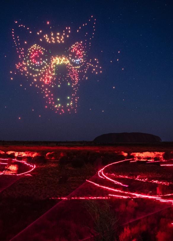 Màn trình diễn drone đầy màu sắc tạo hình một con chó sói trên bầu trời đêm phía trên Uluru trong chương trình Wintjiri Wiru, Vườn quốc gia Uluru-Kata Tjuta, Lãnh thổ phía Bắc © Getty Images for Voyages Indigenous Tourism Australia