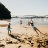 Một nhóm bạn đang chơi bóng gậy trên bãi cát tại Bãi biển Coledale, Vùng Thirroul, Tiểu bang New South Wales © Destination NSW