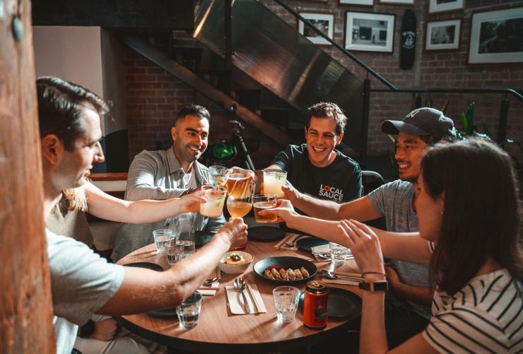 A group of people smiling while raising their glasses at a round table. with Local Sauce Tours, Sydney, New South Wales © Local Sauce Tours