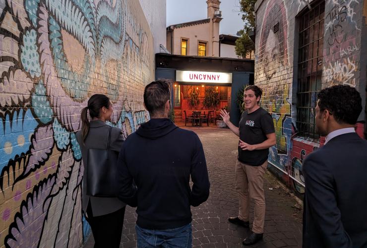 A group of people raising cocktails and glasses of beer around a wooden table in a dimly lit venue. with Local Sauce Tours, Sydney, New South Wales © Local Sauce Tours