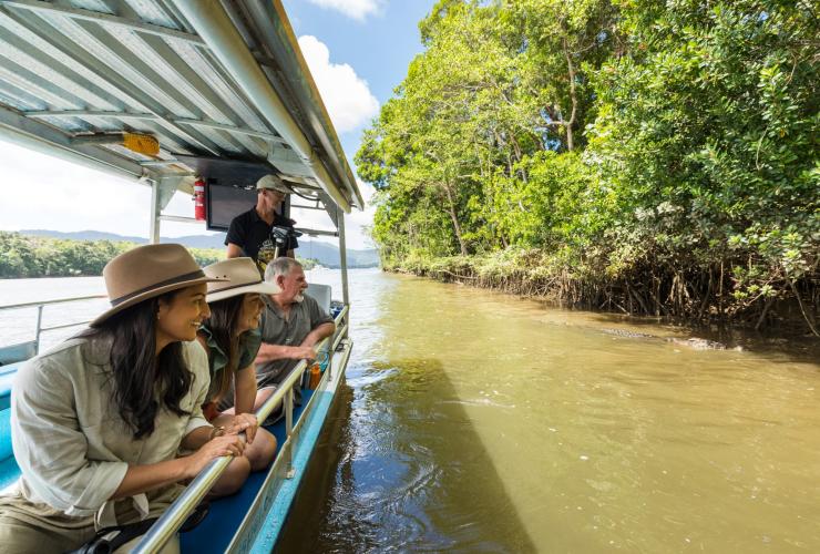 Guests watching an estuarine crocodile swimming beside their boat during a tour with FNQ Nature Tours, Daintree, Queensland © Tourism Australia