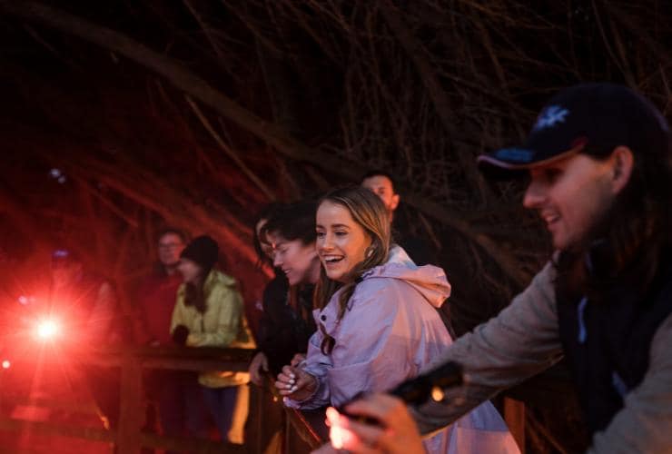 A tour group smiles as they look for little penguins with Bicheno Penguin Tours, Bicheno, Tasmania © Tourism Australia