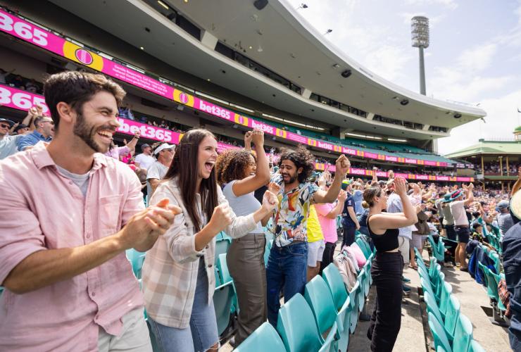 A group of friends cheering in the stands at the Sydney Cricket Ground, Sydney, New South Wales © Destination NSW