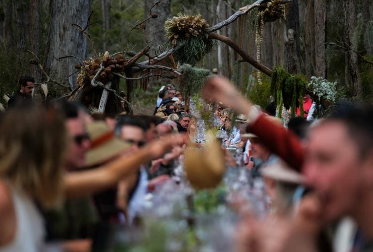 A long table of diners raising their wine glasses in the forest at Pair'd, Margaret River, Western Australia © Tourism Western Australia