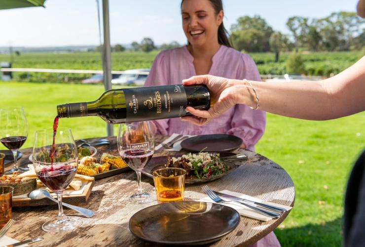Pouring red wine at a table with friends at Barossa Unique Tours, Barossa, South Australia © Tourism Australia 