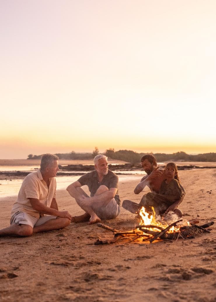 A group of people sit around a campfire on the beach at Tarntipi Bush Camp, Tiwi Islands, Northern Territory © Tourism NT/Helen Orr 