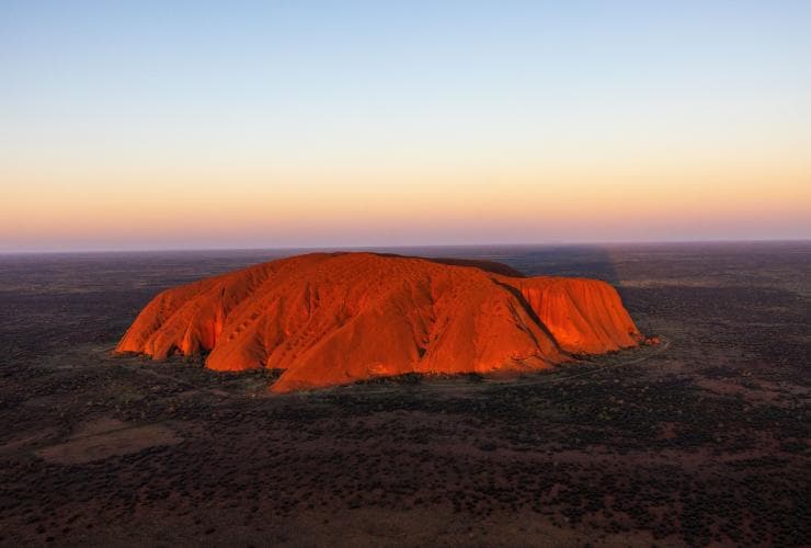 An aerial view of Uluru among the flat outback landscape, Uluru, Northern Territory © Tourism NT/Sean Scott