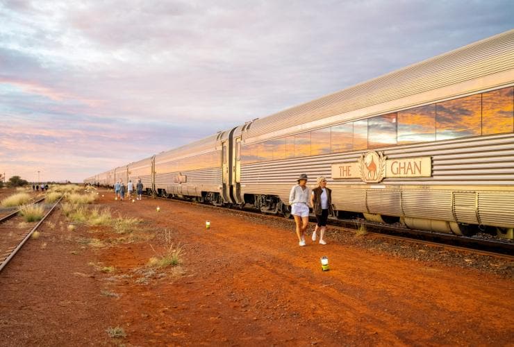 Two women walk alongside The Ghan passenger train at Yorkey's Crossing, Port Augusta, South Australia © Tourism Australia 