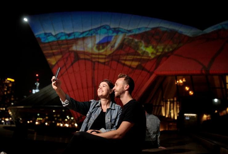 一對情侶晚上在新南威爾士州悉尼市悉尼歌劇院前自拍©Ken Leanfore