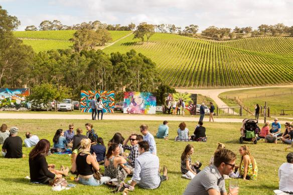 人群在南澳（South Australia）阿德萊德山（Adelaide Hills）長景葡萄園（Longview Vineyard）The Piece Project的草地上野餐，遠處是葡萄園景致©Adelaide Photographers