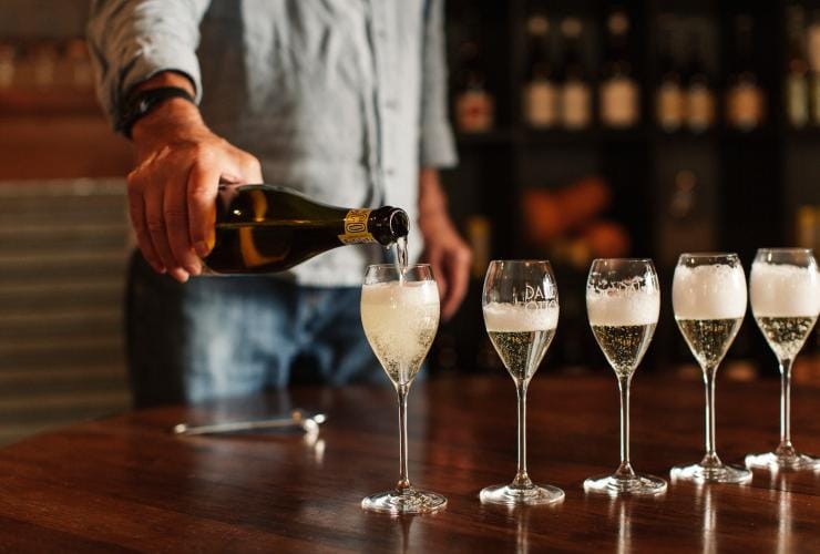 一位旅客在維多利亞州國王谷Dal Zotto Wines酒窖品酒室倒Prosecco©澳洲旅遊局/澳洲維多利亞州旅遊局