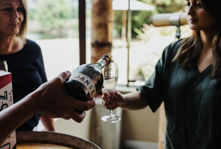 一位旅客在塔斯曼尼亞塔瑪谷的Jansz Tasmania酒窖品酒室倒氣泡酒©Adam Gibson