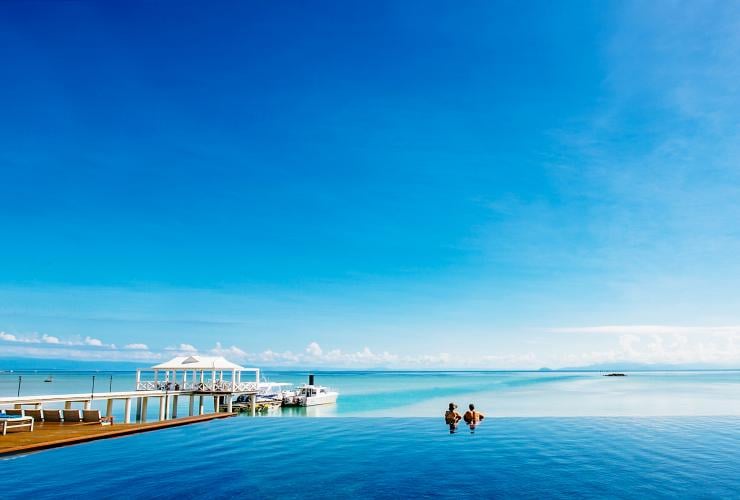 昆士蘭州奧費斯島的奧費斯島度假酒店內一對情侶從無邊際泳池遠眺海洋©奧費斯島