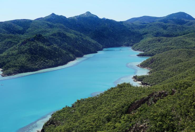 從空中俯瞰昆士蘭州qualia酒店附近拿拉水灣鮮藍色的水面，周圍是漢密爾頓島的綠林©qualia