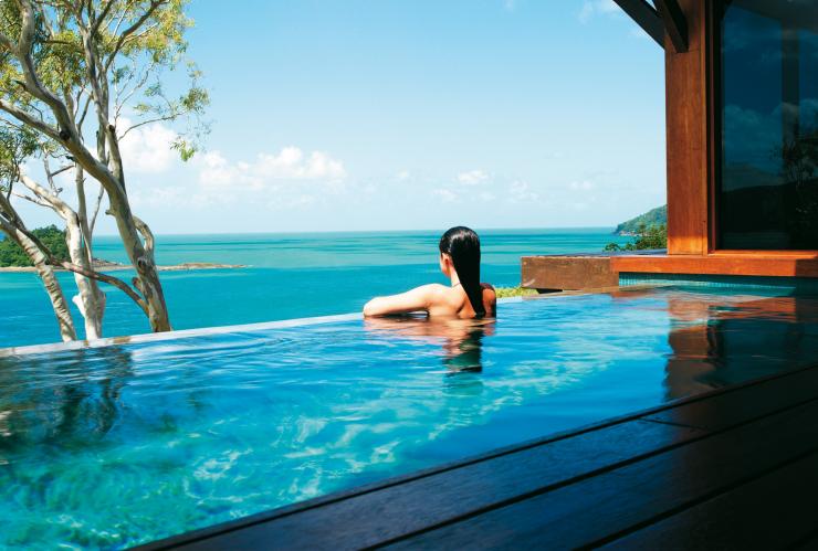 昆士蘭州漢密爾頓島qualia酒店內一位女士倚在遠眺海洋的無邊際泳池邊©Jason Loucas Photography